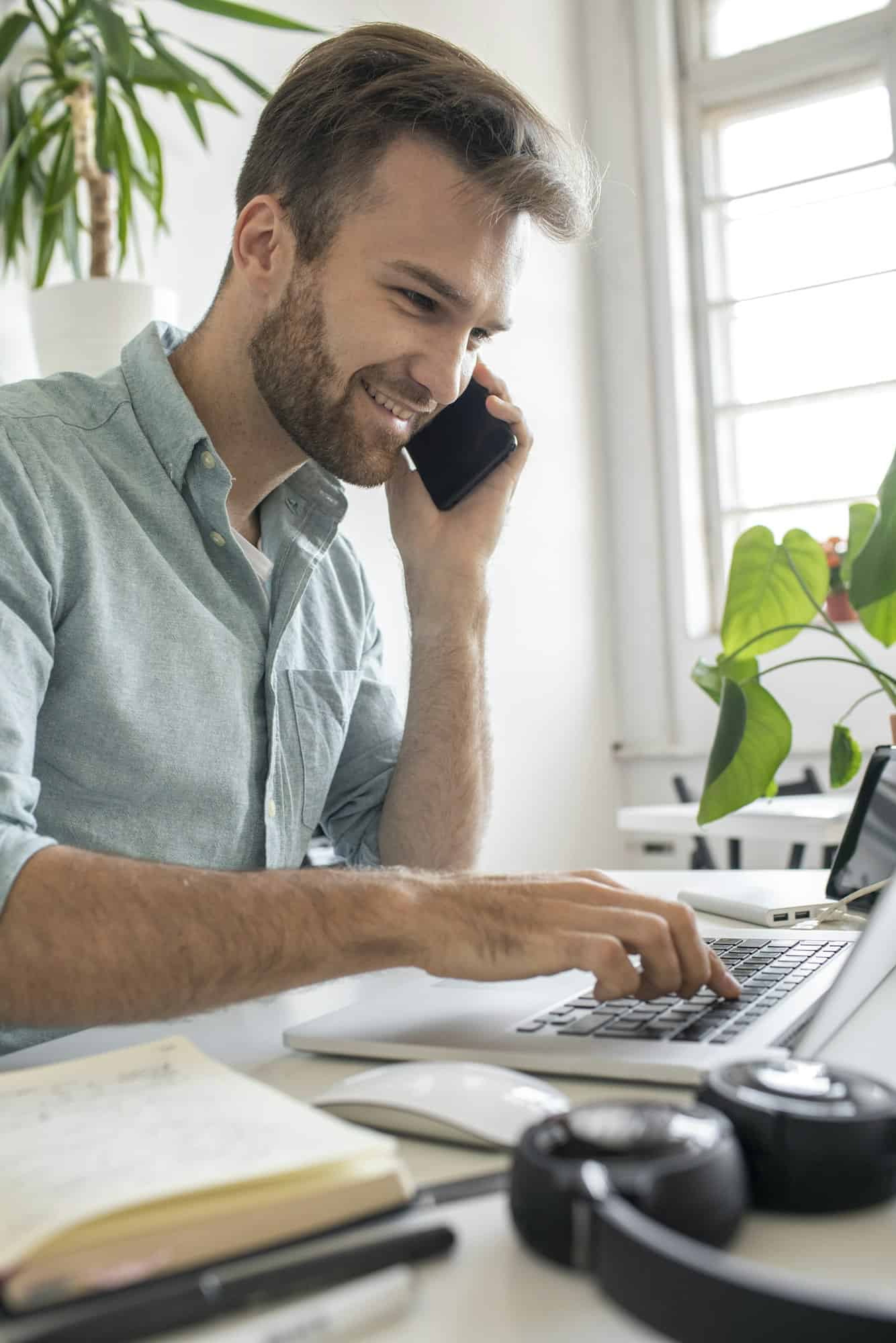 Smiling man on the phone at desk in office